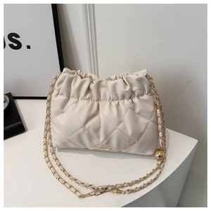 Detail of quilted leather crossbody bag with drawstring design and gold chain strap