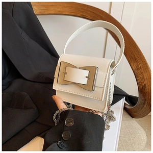 Detail of white PU leather mini bag with large silver geometric buckle and chain strap