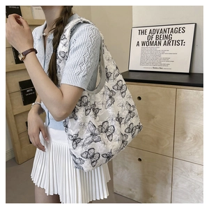 Detail of white tote bag with black butterfly patterns and 3D textured embroidery fabric