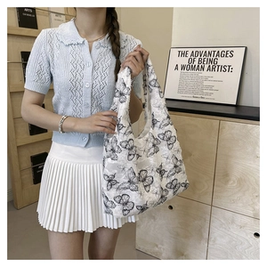 Lace canvas tote bag with black butterfly embroidery pattern shown on a female model