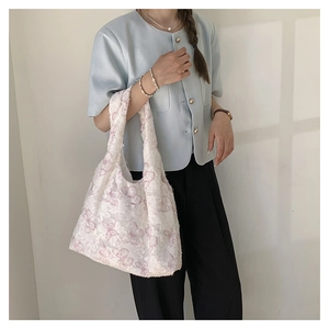 Close-up of white tote bag featuring purple butterfly embroidery and textured fabric