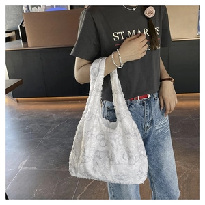 Detail of soft white plush tote bag featuring grey butterfly patterns and fuzzy texture