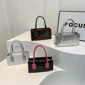 Chic croc-effect rectangle handbags in assorted contrast colors on a tiered display