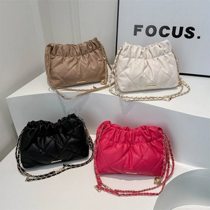 Quilted chain shoulder bags in khaki, white, black and rose pink on display stands