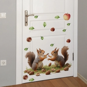 Détail d'autocollants muraux écureuil et fleurs sur une porte en bois blanc