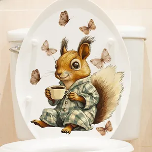 Detail of cute squirrel drinking coffee sticker on a white bathroom toilet lid