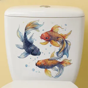 Detailed view of watercolor goldfish stickers on a white ceramic toilet tank surface