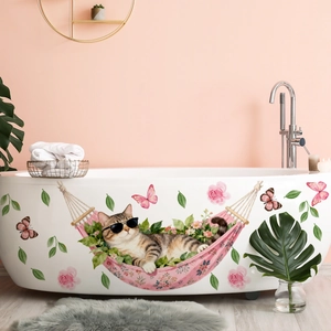 Détail d'un sticker mural chat dans un hamac rose posé sur le côté d'une baignoire blanche