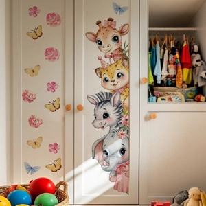 Détail de stickers muraux girafe et éléphant sur une porte d'armoire en bois blanc
