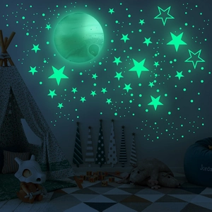 Luminous wall sticker set showing realistic full moon and glowing stars in a cozy bedroom