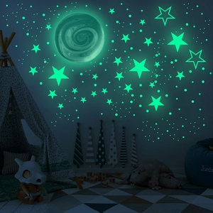Luminous wall stickers featuring moon and stars glowing in green for kids' bedroom decor