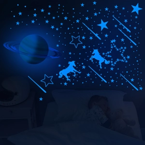 Luminous wall stickers set showing glowing blue stars and unicorn in a dark kids room