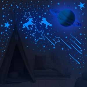 Luminous wall stickers showing glowing blue unicorns and stars in a dark nursery room