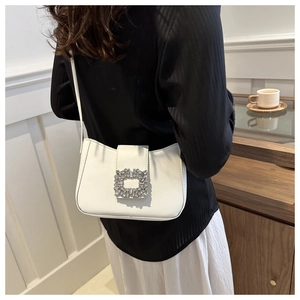 Close-up of white leather shoulder bag featuring a luxury square rhinestone buckle detail