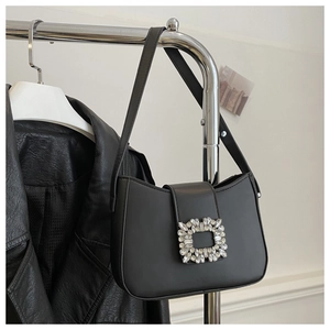 Detail of elegant black baguette bag featuring a large sparkling crystal rectangle buckle