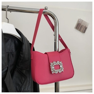 Close-up of rose red shoulder bag featuring a sparkling crystal buckle detail