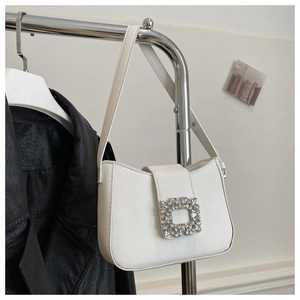Detail of white leather baguette bag featuring a signature square crystal buckle
