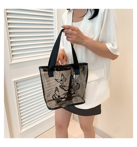 Detailed view of the black butterfly print on a large transparent summer tote bag