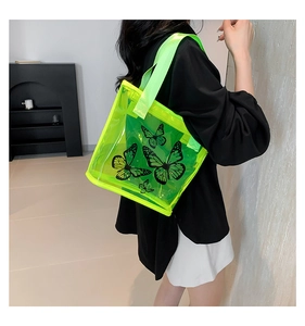 Detail of neon green transparent tote bag with black butterfly prints and sturdy strap