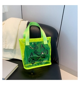Detail of neon green transparent PVC tote bag with black butterfly prints on a leather seat