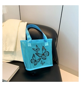 Detail of light blue transparent PVC tote bag with butterfly print and woven handles