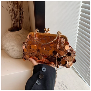 Macro shot of rose gold sequin clutch bag with metal frame and gold chain strap detail