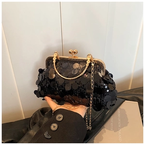 Detail of vintage black sequin shell bag with golden metal handle and chain strap