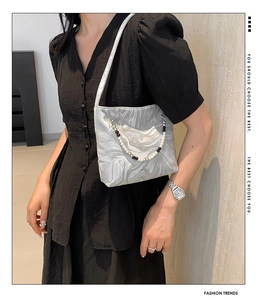 Detail of silver marble satin shoulder bag with pearl and black beaded chain accent