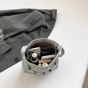 Top view showing the spacious interior of the light grey bucket bag with daily essentials