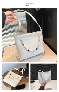 Detail of white marble pattern handbag with decorative beaded chain and long strap