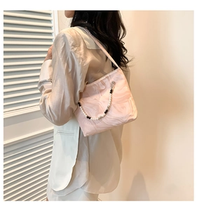 Detail of pink marble pattern shoulder bag featuring a mixed bead and pearl handle strap