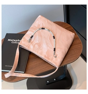 Detail of light pink marble texture surface and elegant beaded handle on shoulder tote bag