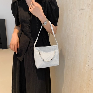 White marbled underarm bag with beaded chain strap and abstract pattern on fabric