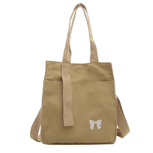 Minimalist canvas tote bag in khaki with a white bow print and adjustable straps