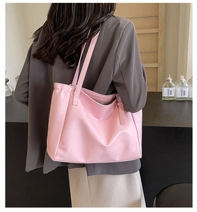 Pink large capacity tote bag shown on shoulder with side metal buckle detail