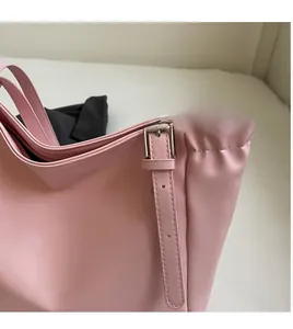 Detail of pink leather tote bag showing adjustable shoulder strap and silver metal buckle