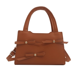 Chic brown leather handbag featuring sparkly bow accents and adjustable strap