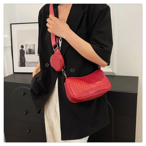 Détail du sac croissant rouge à texture tissée avec porte-monnaie et bandoulière