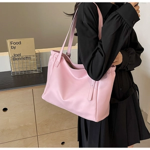 Detail of light pink leather tote bag with soft pleated edges and slim shoulder strap