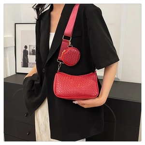 Détail du sac bandoulière rouge tressé avec petit porte-monnaie rond sur la sangle