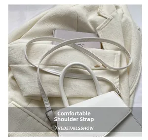Detail showing the comfortable adjustable shoulder strap on a white leather handbag
