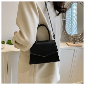 Chic black matte leather bag on model showing a versatile crossbody and handbag style