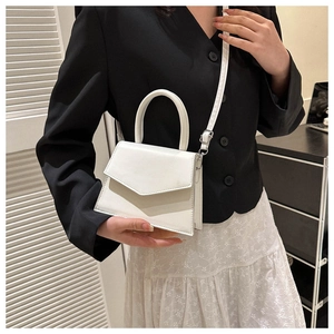 Close-up of a white mini PU leather handbag with V-shaped stitching and silver hardware