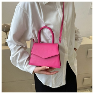 Detailed macro shot of a rose pink mini leather handbag worn by a model in lifestyle setting