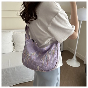 Detail showing lavender crescent bag with embossed texture and colorful wavy embroidery