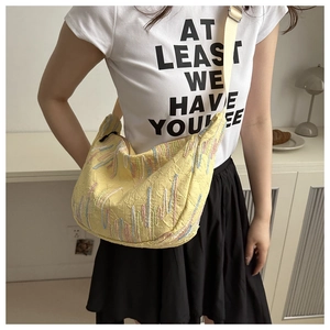 Detail of yellow nylon crossbody bag featuring colorful wave stitching and strap buckle