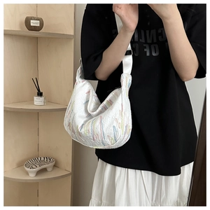 Close-up of white crescent hobo bag featuring colorful vertical embroidery and pleated texture