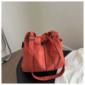 Detail view of caramel orange canvas bag featuring a drawstring closure and black toggle