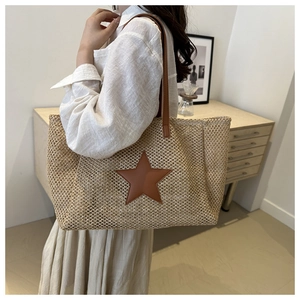 Close-up of woven straw tote bag with brown leather star patch and durable PU straps