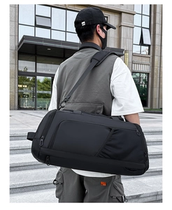 Homme portant un grand sac à dos de sport noir imperméable avec bretelles rembourrées